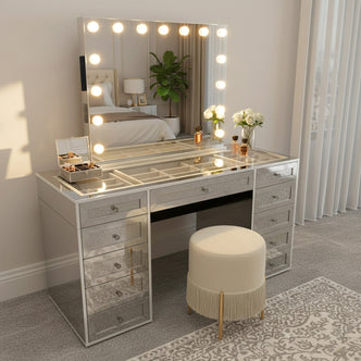 Ivy Diamond Crystal Mirror Finish Hollywood LED Vanity Table with glowing bulb-framed mirror, mirrored drawers, and tempered glass top, featuring beauty items, vanity stool, and elegant bedroom setting.