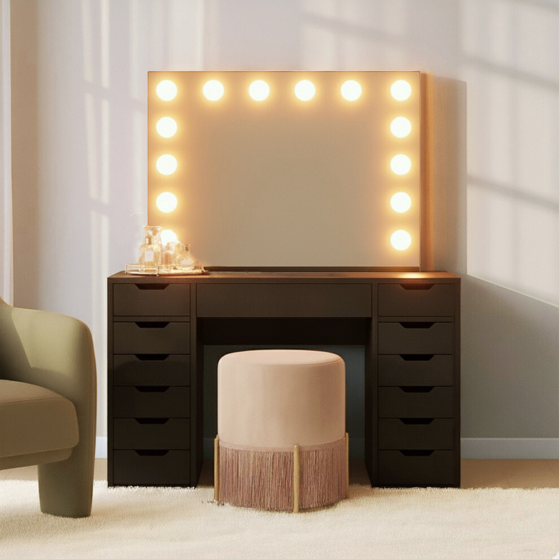 Jenna Hollywood Makeup Vanity Table with LED Mirror in Black, featuring a large bulb-outlined mirror, black drawer-stacked design, soft pink stool, and glass tray with perfumes on a plush carpet.