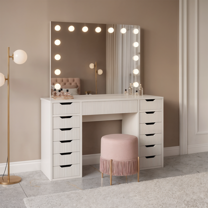 Jenna Fluted Makeup Vanity Table with Hollywood LED Mirror in White, featuring a large mirror with 13 bulbs, 13 drawers, and a spacious tabletop. Paired with a pink stool and gold lamp.