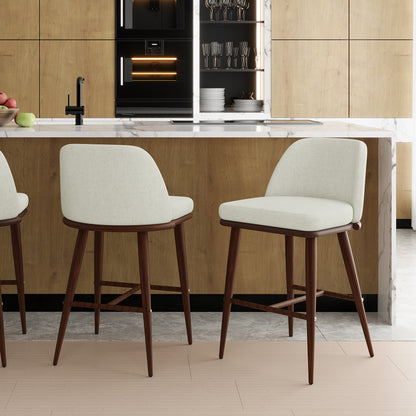 Jeremi High Back Linen Bar Stool Set of 2 in Wheat Walnut, featuring light-colored upholstered seats and dark wooden legs, positioned in front of a modern kitchen island with a marble countertop.