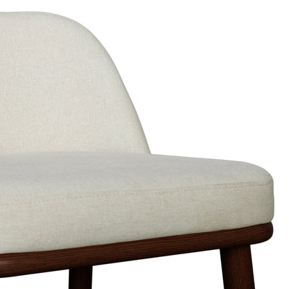 Jeremi High Back Linen Bar Stool Set of 2 in Wheat Walnut, showcasing a close-up of a light-beige upholstered seat and backrest on a dark wood frame with matching wooden legs.