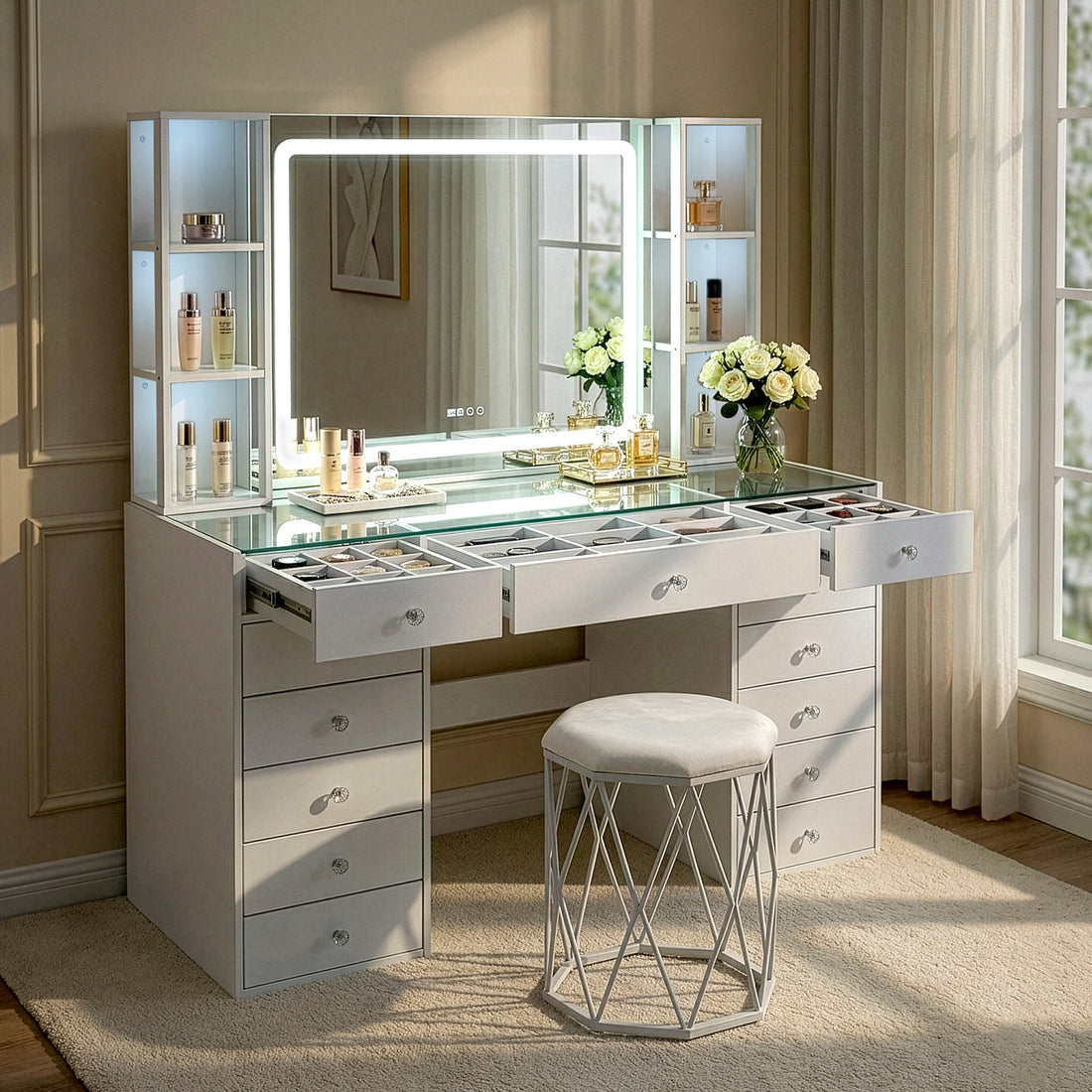 White vanity table with lighted mirror and stool styled in a softly lit room