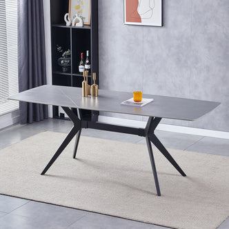 Keneddy 200cm Ceramic Porcelain Dining Table in Concrete with sleek black metal “X”-style legs, set on a beige rug, adorned with gold candleholders and amber-orange glass decor.