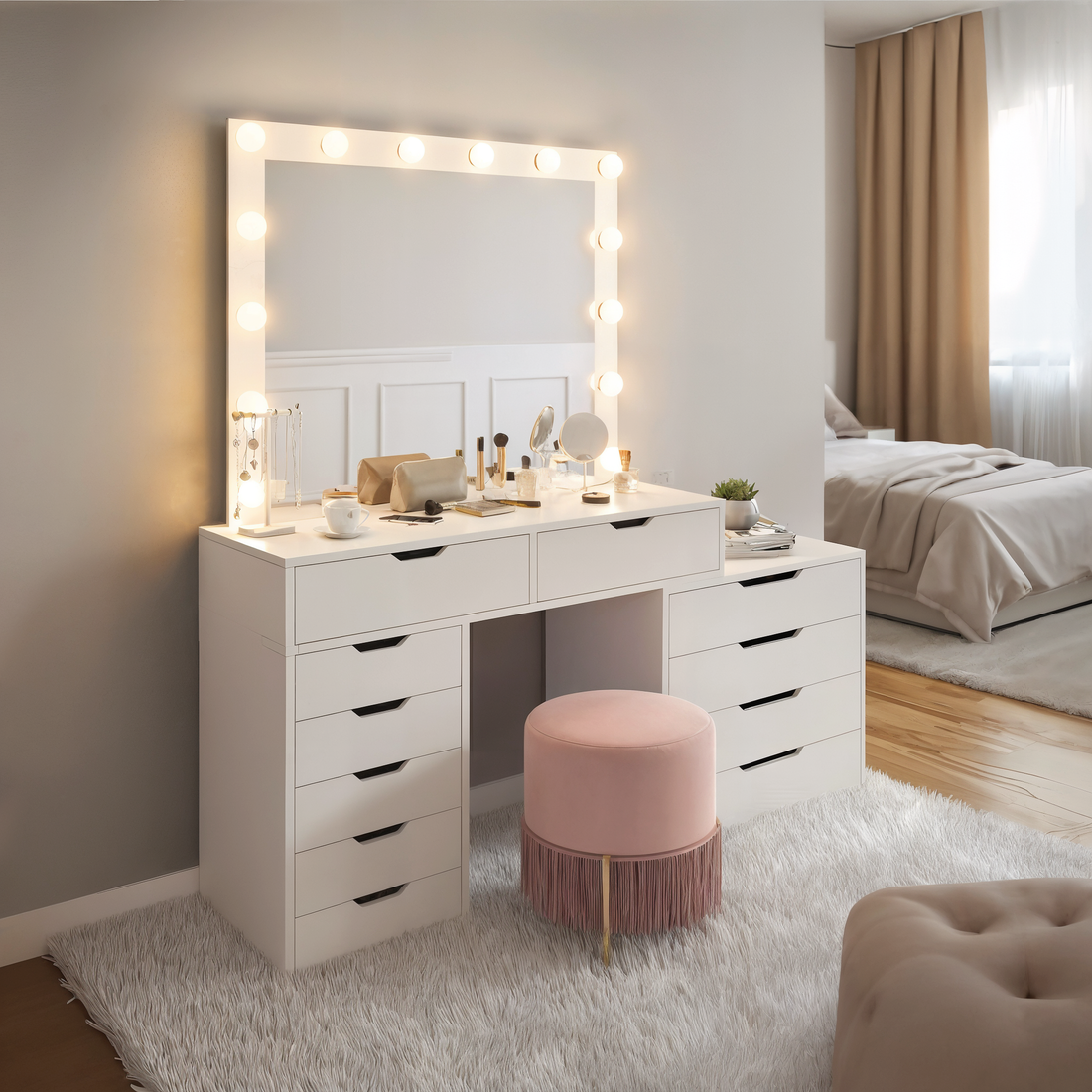Lassie Hollywood Vanity Dressing Table with Drawers in White features a lighted mirror, multiple stacked drawers, makeup items, and a pink stool, creating a chic, glamorous dressing area.