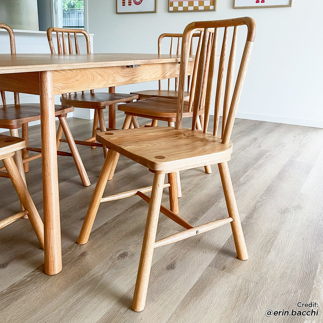 Leigh Solid Oak High-back Dining Chair Natural Set of 2 showcased with a spindle-back design, rounded seat corners, and low footrest, in a modern dining area featuring a matching oak table and chairs.