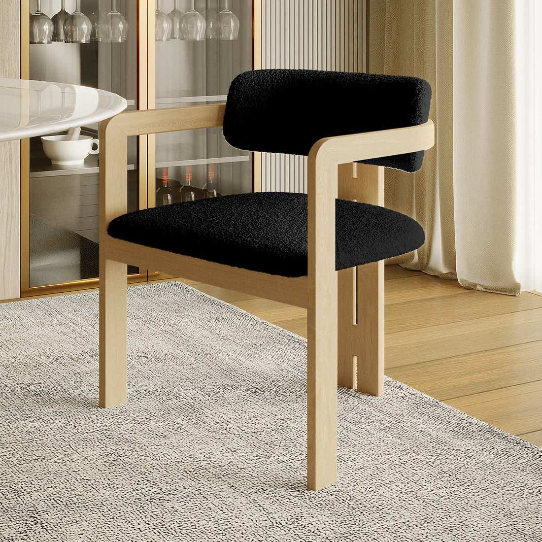 Maddi Boucle Hardwood Dining Chair Black with curved backrest, armrests, and plush boucle upholstery. Features a minimalist design with a sturdy American wood frame, ideal for modern dining spaces.