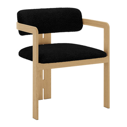 Maddi Boucle Hardwood Dining Chair Black with wooden armrests, curved backrest, and thick cushions, showcasing a minimalist design with ergonomic features on a solid American wood frame.