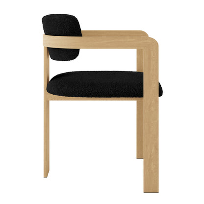 Close-up of the Maddi Boucle Hardwood Dining Chair Black, highlighting its curved backrest, soft boucle upholstery, and thick cushions on a solid American wood frame, emphasizing comfort and elegant design.
