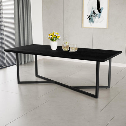 Mae 220cm 8 Seater Rectangular Dining Table in Black with a dark wood-grain finish, geometric “X”-style metal legs, adorned with a vase of tulips, a glass pitcher, and drinking glasses.