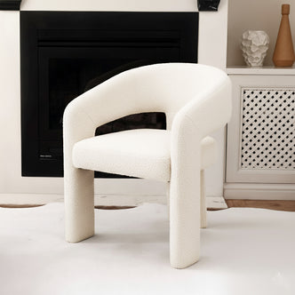 Mariah 3 Legged Boucle Accent Chair in Cream White centered in cozy living space, featuring a modern U-shaped silhouette, cream bouclé upholstery, and a stable three-legged hardwood frame against a neutral-toned backdrop.