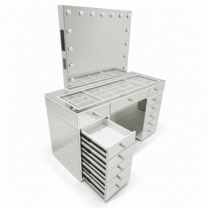 Monroe Hollywood Makeup Dressing Table in Silver featuring a frameless mirror with vanity bulbs, glass-topped counter with compartments, multiple drawers, and a pull-out drawer tower.