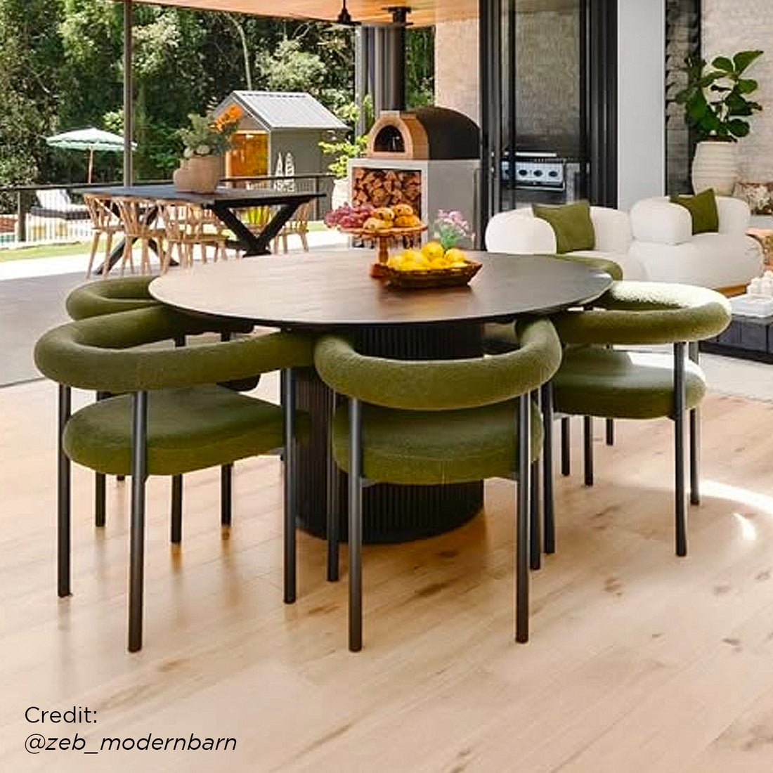 Ohio Curved Bouclé Dining Chair Set of 2 in Green, featuring a sleek black frame, tubular backrest, and slim legs, complements the indoor-outdoor dining space's modern, seamless blend of style and comfort.