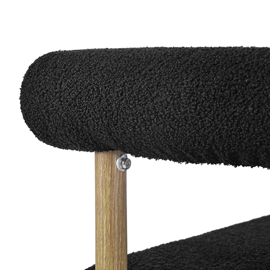 Close-up of the Ohio Curved Boucle Dining Chair Set of 2 in Black & Oak, featuring two horizontal tubular cushions in black boucle fabric, supported by a vertical wooden post with a visible bolt.