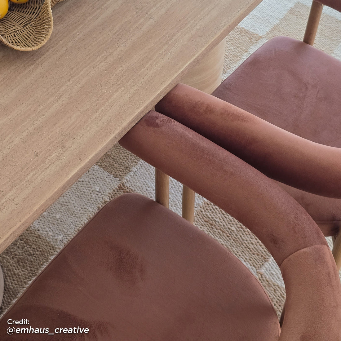 Ohio Velvet Dining Chair Set of 2 in Mocha Mousse & Oak, featuring blush velvet upholstery and curved backs with slim wooden legs, is elegantly positioned under a light-toned wooden table on a woven rug.