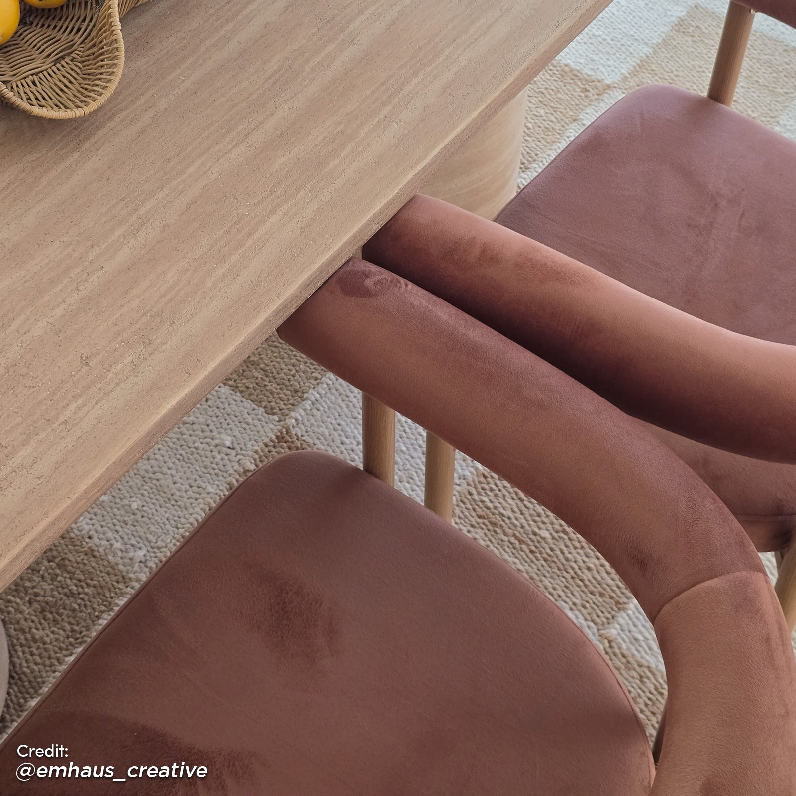 Ohio Velvet Dining Chair Set of 2 in Mocha Mousse & Oak, featuring blush velvet upholstery and curved backs with slim wooden legs, is elegantly positioned under a light-toned wooden table on a woven rug.