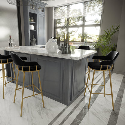 Piper Velvet Fabric Bar Stool Set of 2 in Black features black upholstered seats and slender gold-metal legs, accentuating a modern kitchen with a central white marble island and elegant decor.