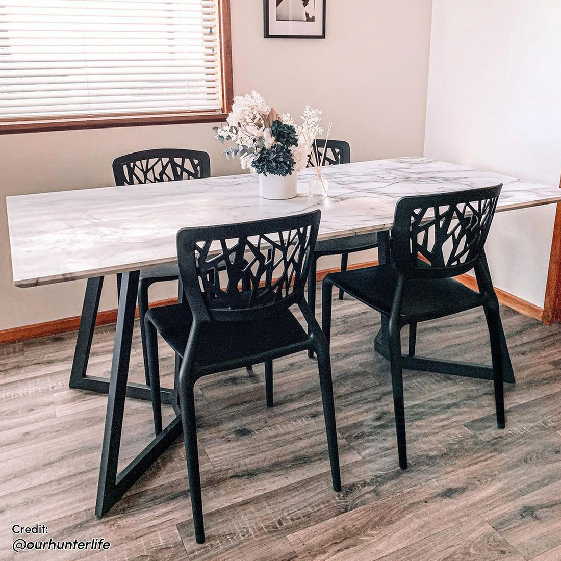 Salen 180cm White Marble Dining Table with a sleek marble-like top and distinctive geo design black metal legs, comfortably seating 6-8 people, ideal for modern dining settings.