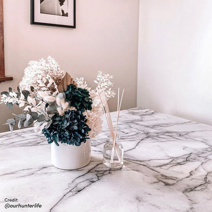 Close-up of Salen 180cm White Marble Dining Table with a sleek marble top and geometric black metal legs, perfectly suited for seating 6-8, embodying Scandinavian elegance for versatile dining settings.