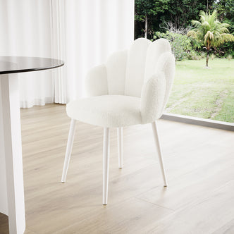 Sally Scalloped Bouclé Dining Chair Set of 2 in Cream White, features a shell-inspired backrest and slender white metal legs, set in a bright, minimalist interior with a light wood floor.