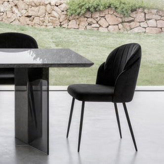 Scarlett Velvet Dining Chair Set of 2 in Black, featuring plush velvet upholstery and slender metal legs, paired with a matching black dining table with a polished stone top and pedestal base.