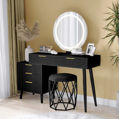 Serenity Makeup Vanity Table with LED Touch Mirror in Black, featuring ribbed drawers, gold handles, round backlit mirror, pampas grass vase, lipsticks, compacts, and a cushioned stool.