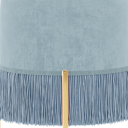 Stacey Tassled Velvet Ottoman Foot Stool in Blue, featuring a pale blue cylindrical lampshade with textured fabric, adorned with a fine blue fringe, and supported by a warm gold tubular lamp post.