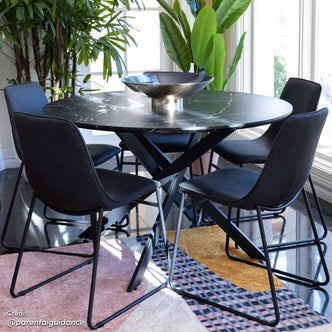 Stoten Round Dining Table Black Marble features a round top with sleek black powder-coated legs, showcasing a modern silhouette ideal for diverse settings.
