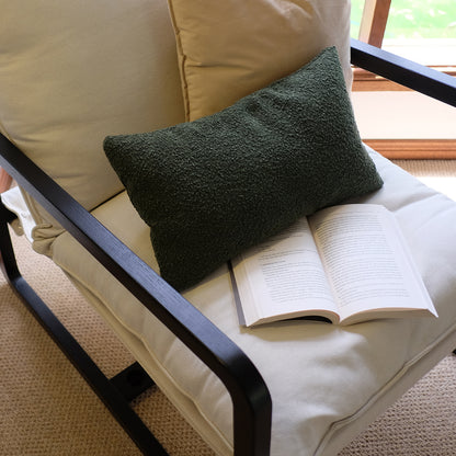 Tilly Linen Hardwood Arm Chair Black with a green throw pillow and book on the seat, showcasing its solid oak frame and plush cushion, epitomizing minimalist comfort and style.