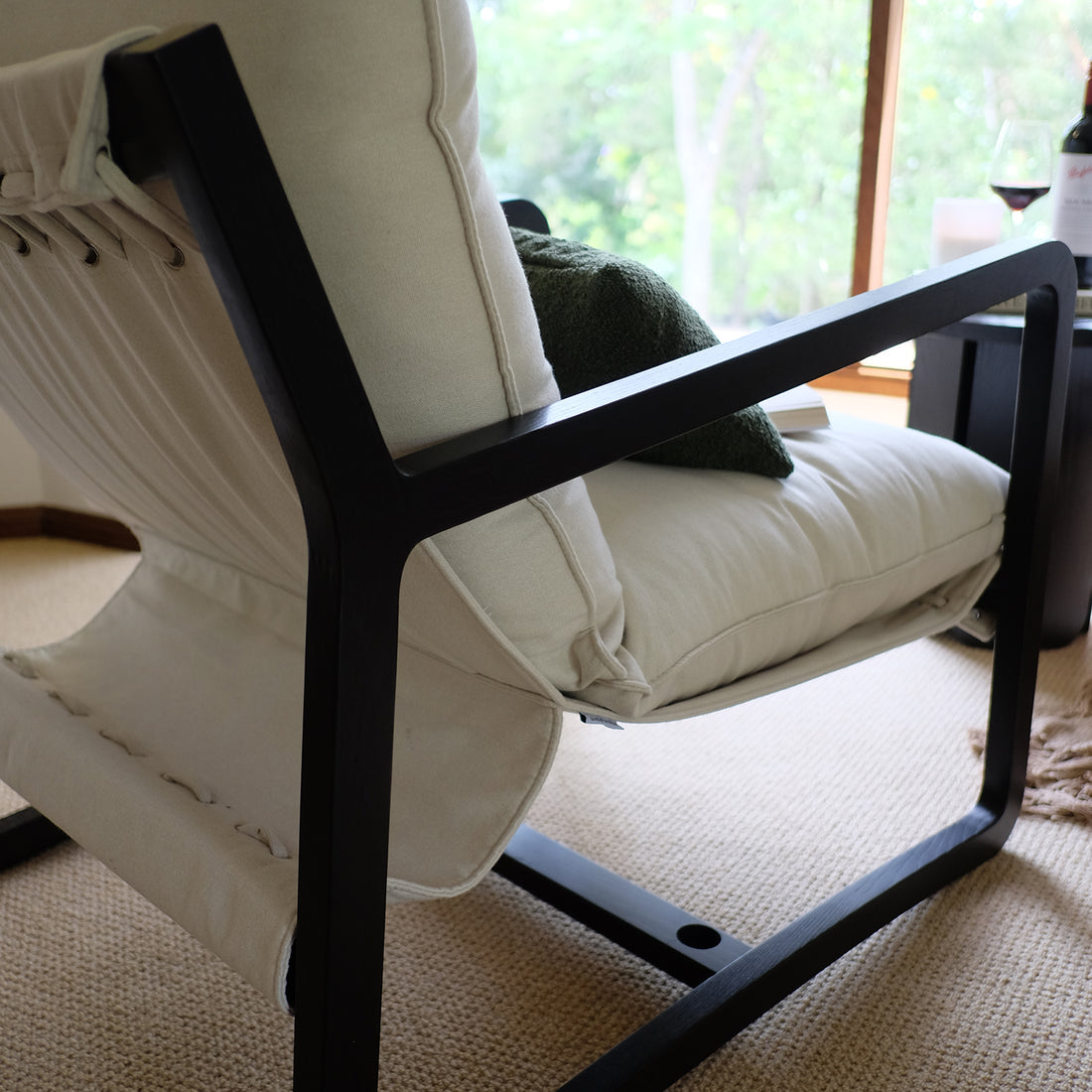 Tilly Linen Hardwood Arm Chair featuring a sleek design with visible armrests and plush cushions, set in a modern indoor space. The chair showcases its sturdy wooden frame and minimalist aesthetic.