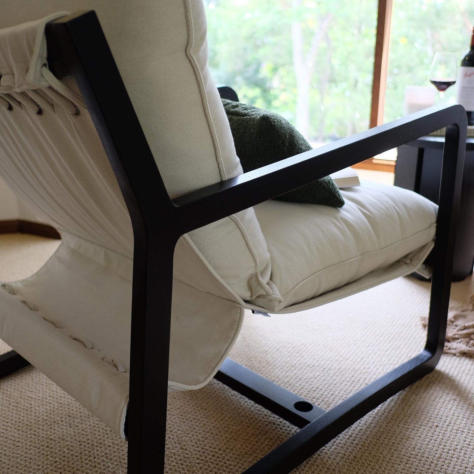 Tilly Linen Hardwood Arm Chair featuring a sleek design with visible armrests and plush cushions, set in a modern indoor space. The chair showcases its sturdy wooden frame and minimalist aesthetic.