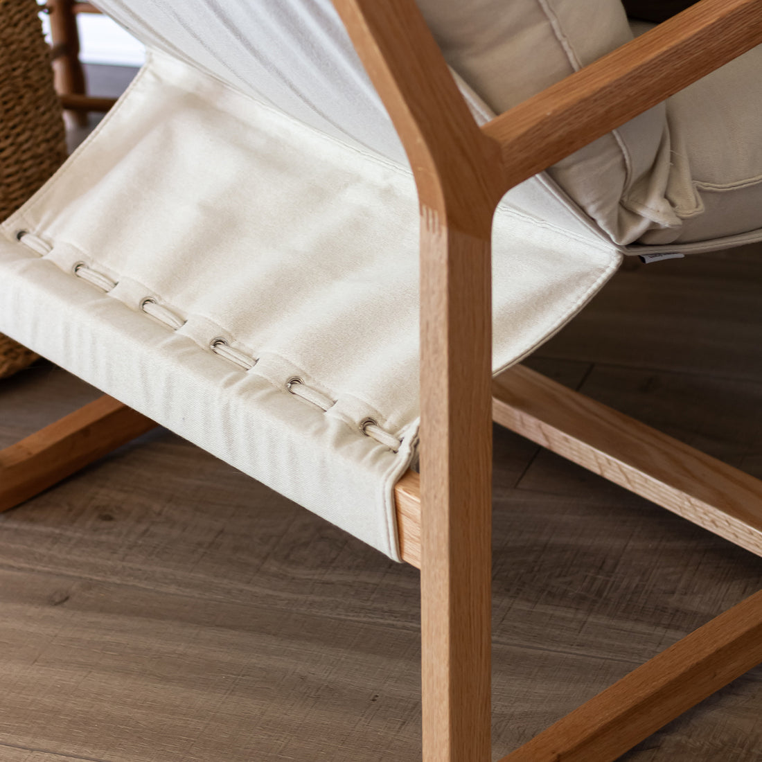 Tilly Linen Hardwood Arm Chair features a close-up view of its sturdy American oak frame and plush, high-density foam cushions, showcasing its minimalist and elegant design ideal for modern living spaces.
