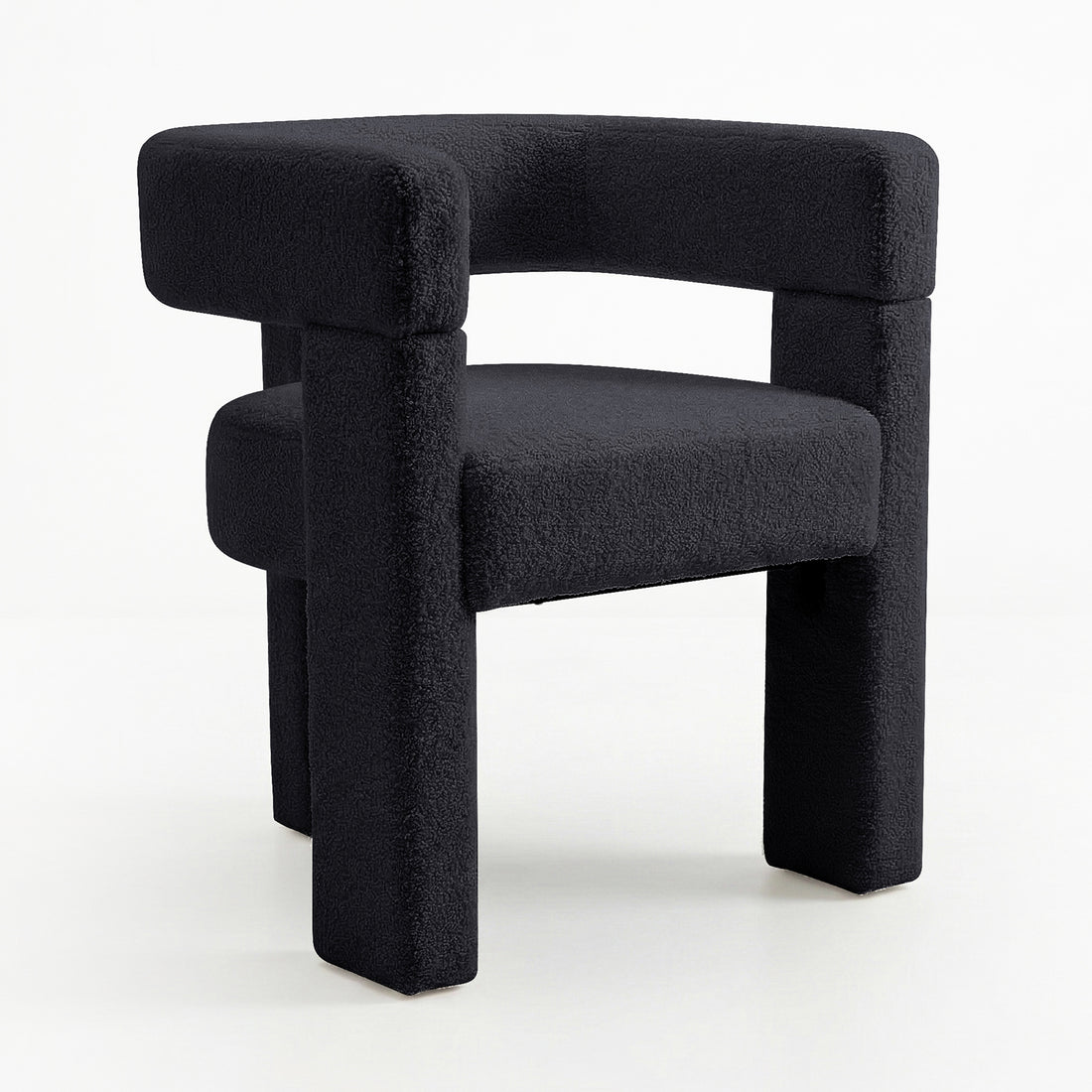 Utah Bouclé Curved 3 Legged Accent Chair in Black with a sculptural design, featuring a textured black fabric, curved backrest, chunky tubular legs, and a unique three-legged silhouette for modern elegance.