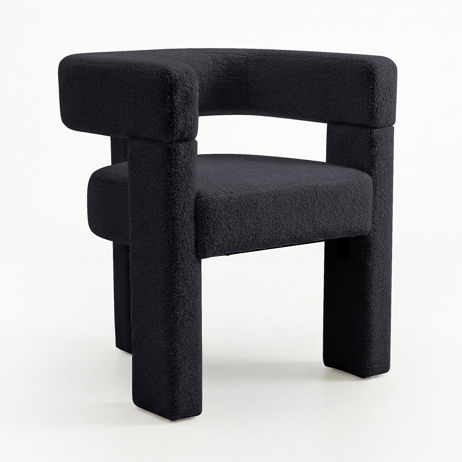 Utah Bouclé Curved 3 Legged Accent Chair in Black with a sculptural design, featuring a textured black fabric, curved backrest, chunky tubular legs, and a unique three-legged silhouette for modern elegance.