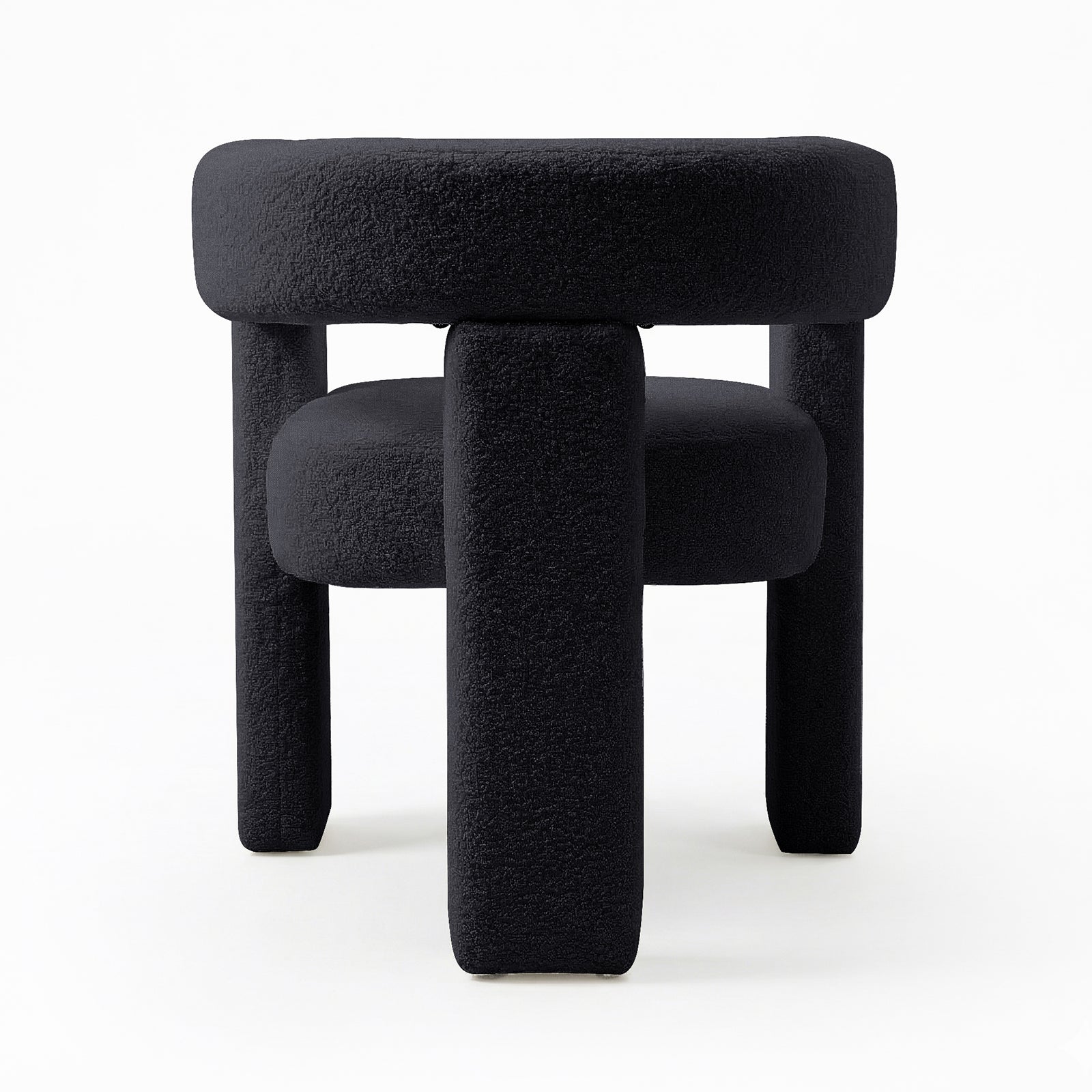 Utah Bouclé Curved 3 Legged Accent Chair in Black, featuring a modern, sculptural design with plush bouclé upholstery and three chunky cylindrical legs, offering both comfort and a striking focal point.