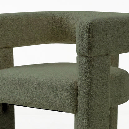 Utah Bouclé Curved 3 Legged Accent Chair in Green, featuring a textured gray-green fabric, rounded seat cushion, and curved backrest with high armrests, supported by chunky cylindrical legs for a modern look.