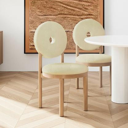 Wubin Boucle Premium Hardwood Dining Chair Set of 2 in Beige, featuring light-wood frames, rounded backs with peek-through holes, and upholstered seats, set on a herringbone-patterned floor.