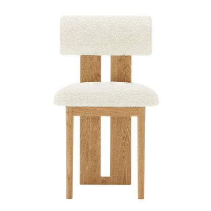 Close-up of a wooden chair with a thick white cushion, highlighting the Wylie Boucle Oak Dining Chair's elegant design and solid oak frame, perfect for modern dining rooms. Set includes two chairs.