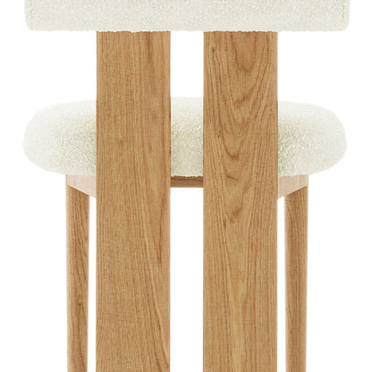 Wylie Boucle Oak Dining Chair Set features a close-up of the plush boucle fabric seat and backrest, solid oak frame, and oak-paneled legs, showcasing its elegant and sturdy design.