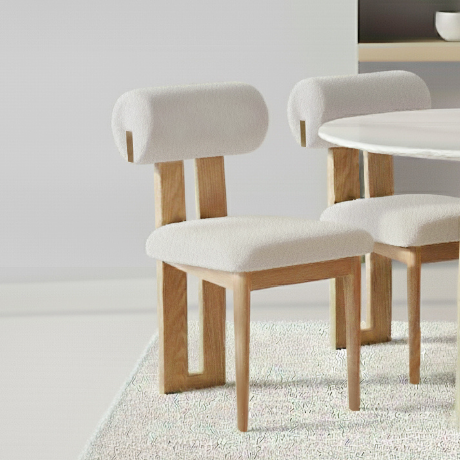 Wylie Boucle Oak Dining Chair Set of 2 in Cream White features wooden frames, off-white upholstered seats, and tubular backrests, positioned on a textured rug with a nearby round, white tabletop.