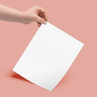 A hand holds Luxelabel Matte Integrated A4 Label Paper, featuring a faint rectangular label outline, ideal for printing labels and documents seamlessly on a single sheet.