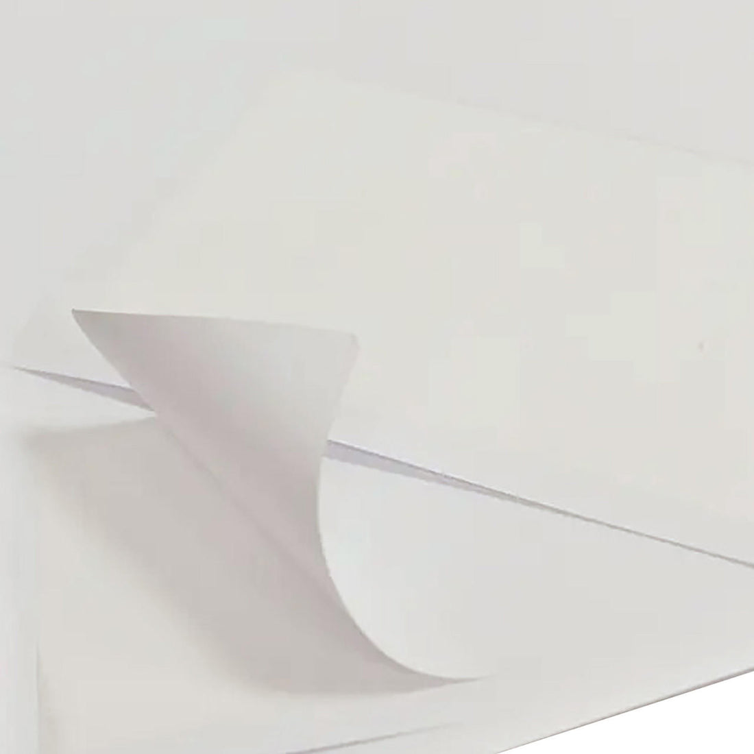 Luxelabel Matte Integrated A4 Label Paper stack with the top sheet's corner curling upward, highlighting its label integration for streamlined printing on eBay/Amazon packing slips.