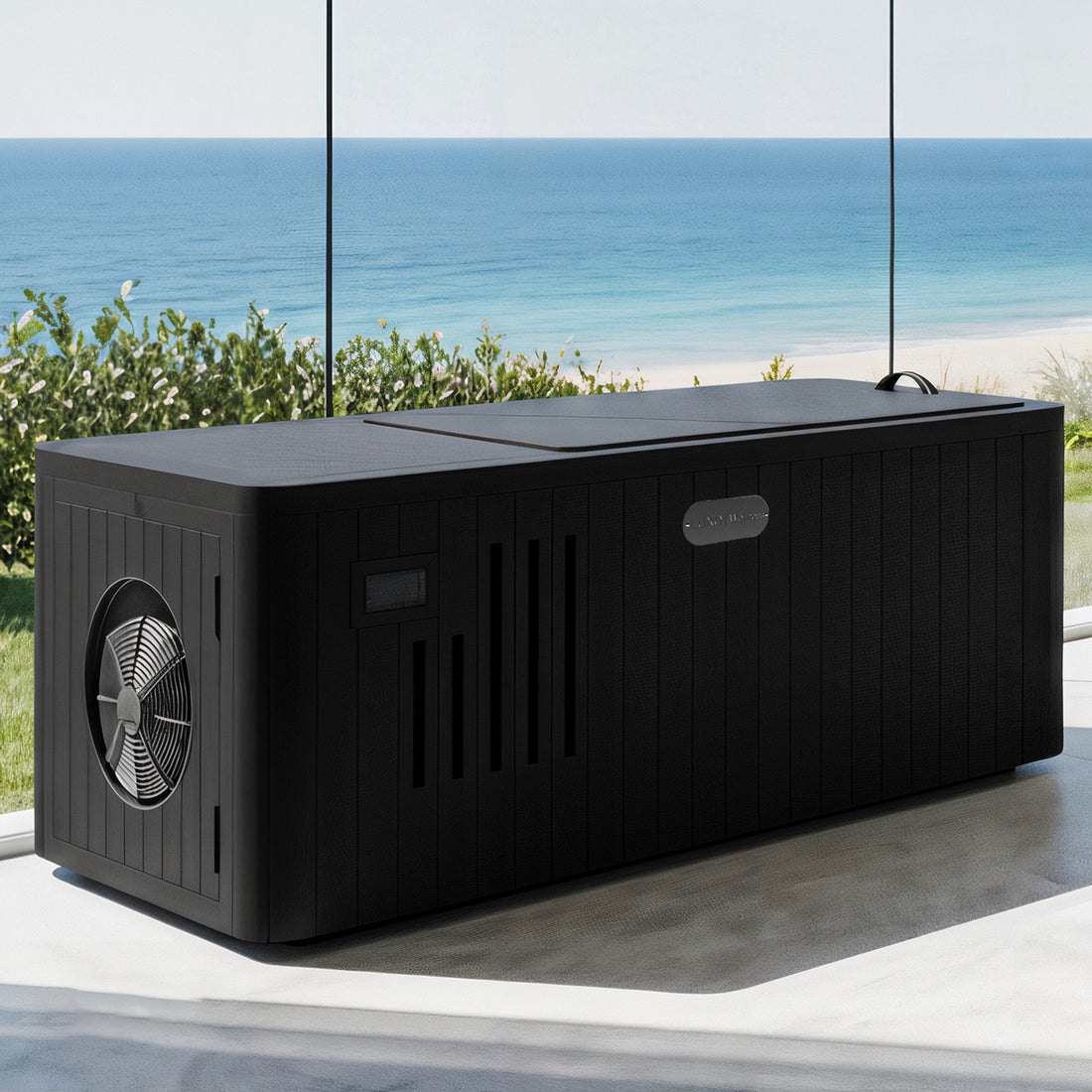 Lambert 2-Person 1HP Chiller Ice Bath in Black, featuring a matte-black exterior with circular fan intake and ventilation slots, set in front of a glass wall with ocean view.