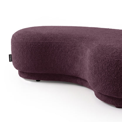 Kidney-bean shaped upholstered seating in rich plum color on a white background