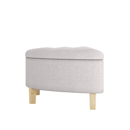 Amina Half Round Linen Fabric Ottoman in Warm Grey, featuring a curved design with tufted upholstery, hinged padded top for storage, and supported by short wooden legs, adding elegance and functionality.