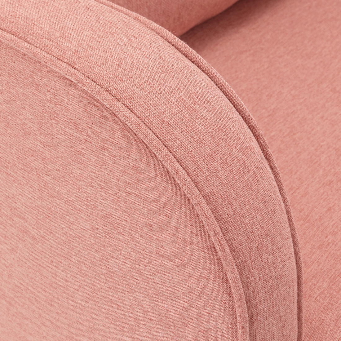 Close-up of the Aura Linen Rocking Chair with Ottoman in Light Pink, showcasing its upholstered arm in soft pinkish-coral fabric with visible piping along the curved edge.