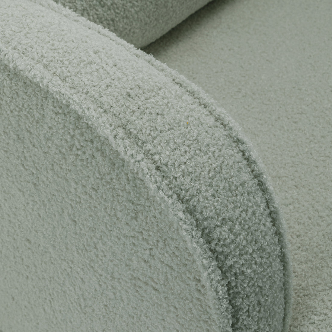 Close-up of Aura Boucle Rocking Chair with Ottoman in Mint Green, showcasing the curved armrest and seat cushion in soft bouclé fabric, emphasizing its cozy and inviting texture and design.