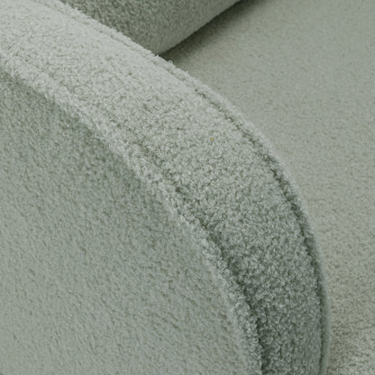 Close-up of Aura Boucle Rocking Chair with Ottoman in Mint Green, showcasing the curved armrest and seat cushion in soft bouclé fabric, emphasizing its cozy and inviting texture and design.