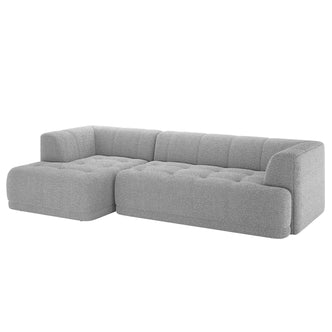 Averill 4 Seater Bouclé Fabric Chaise Sofa in Grey, showcasing a modern L-shaped design with tufted cushions and an extended chaise, upholstered in light-gray textured fabric for a contemporary look.