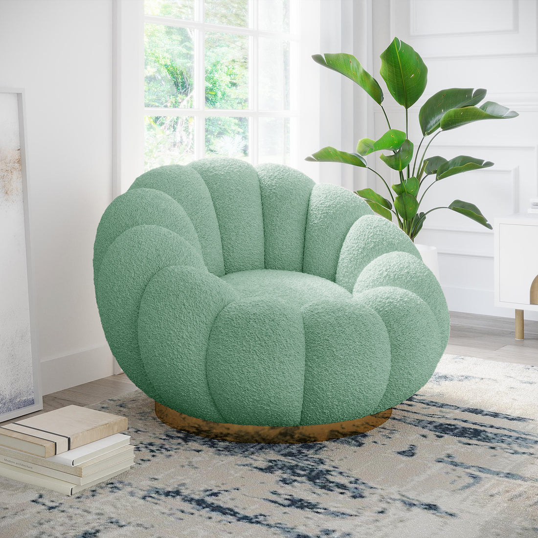 Beare Boucle Swivel Gold Base Accent Chair in Light Green, featuring a plush scallop design, sits on an abstract-patterned rug, accompanied by books and a potted plant near a sunlit window.