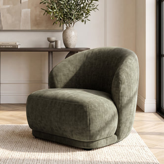 Moss green upholstered accent chair styled in a modern living room